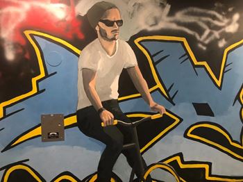 a painting of a man on a bike in front of a graffiti wall